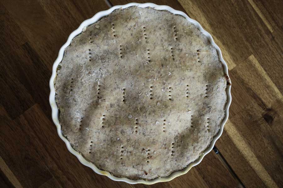 Pâte brisée aux drêches dans un plat à tarte