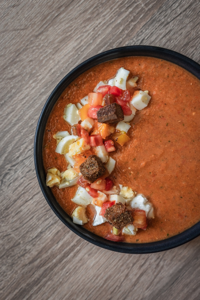 Bol de gaspacho en gros plan, avec des croutons aux drêches de bière